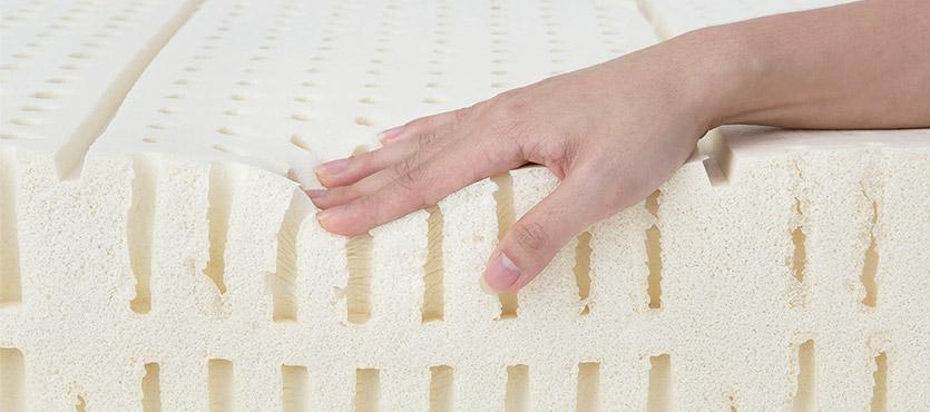 hand pushing down on latex mattress